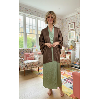 Woman wearing a brown Kimono Jacket Sewing Pattern, styled over a green dress in a bright living room.