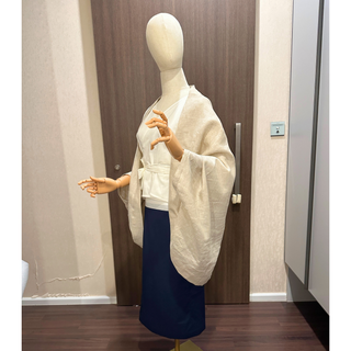 A stylish mannequin wearing a cream-colored Cape Jacket, showcasing the Cape Jacket Sewing Pattern's chic design.
