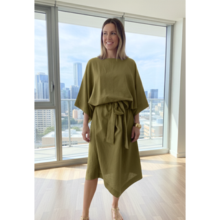 Model wearing a stylish Kimono Dress Sewing Pattern with wide sleeves and a tie waist against a city backdrop.