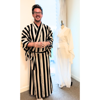Man wearing a black and white striped Men’s Kimono with a mannequin in a white kimono, showcasing a Men’s Kimono Sewing Pattern.
