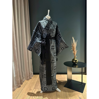 Stylish black and white kimono displayed on a mannequin, showcasing a unique geometric pattern.